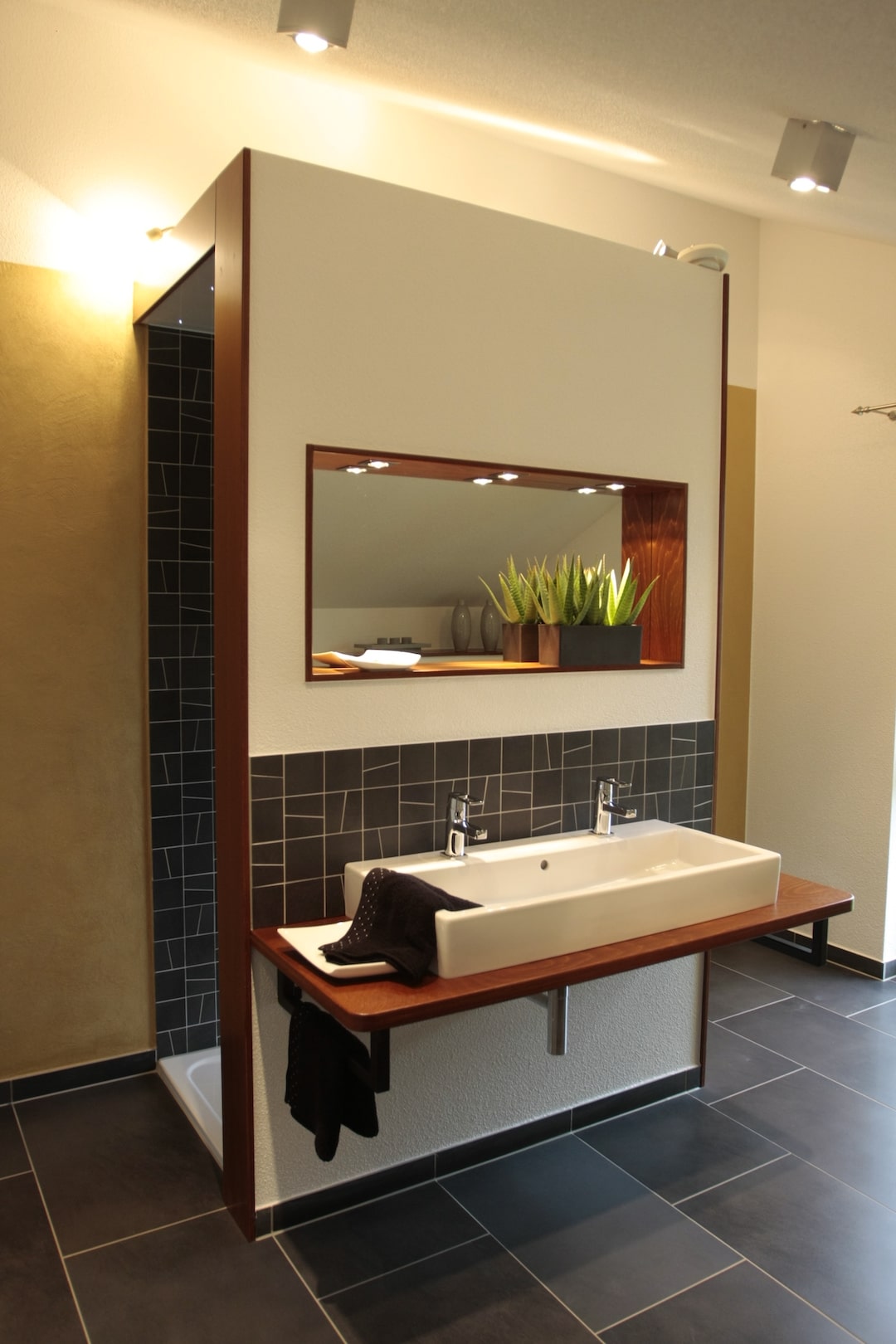 Badezimmer im Partner-Haus Fertighaus mit moderner Waschtischlösung, Spiegelwand und stilvollem Design